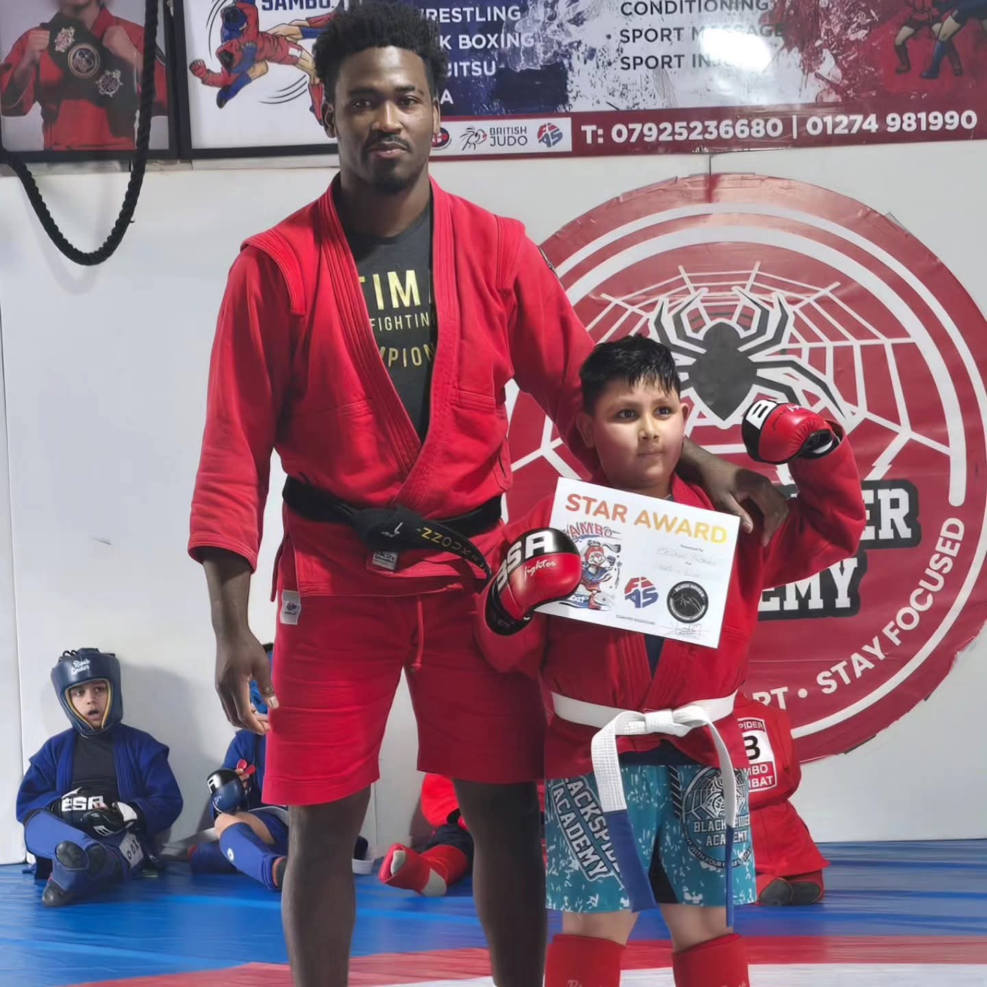 Coach Yannick Nnouka working a takedown with a student